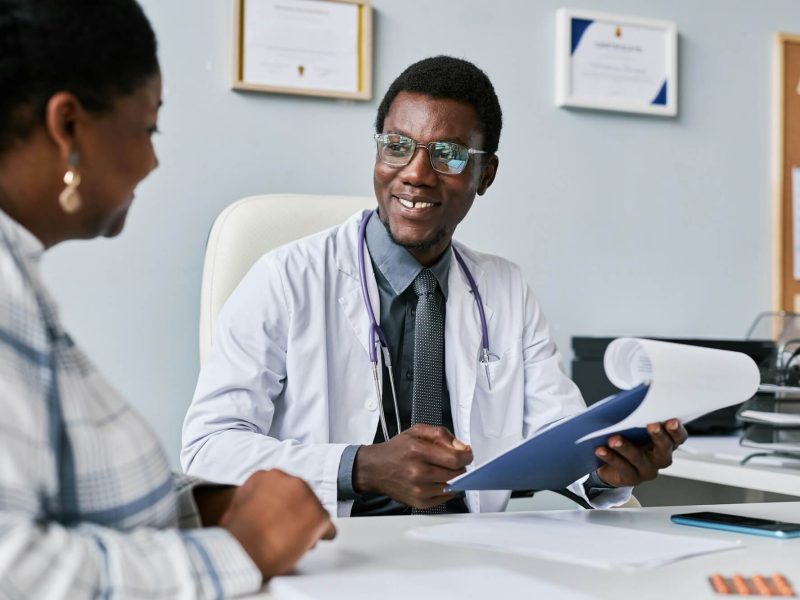 smiling-black-doctor-consulting-female-doctor-in-clinic.jpg